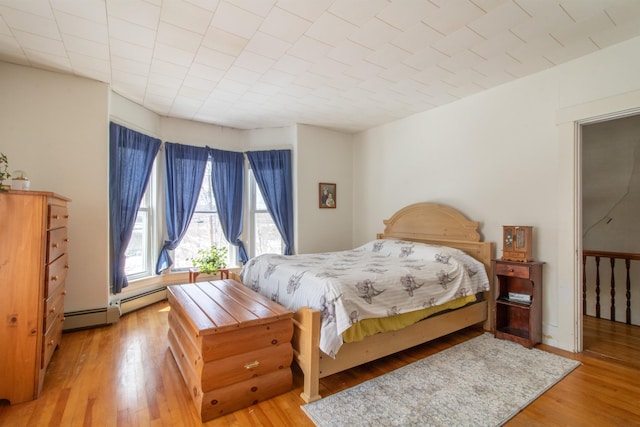 bedroom with baseboard heating and light wood-style flooring