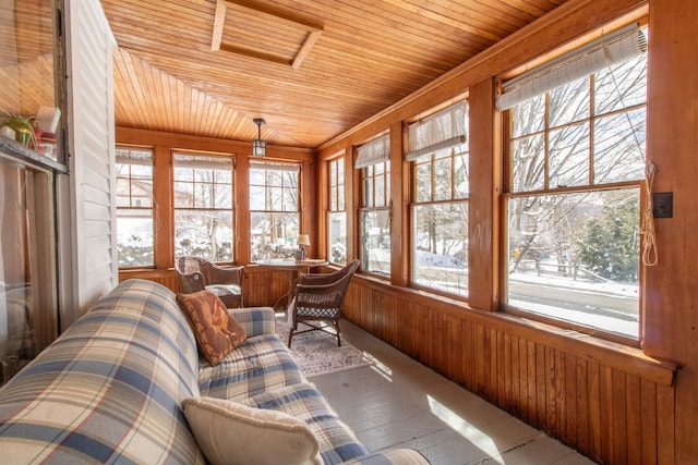 sunroom / solarium with wood ceiling, attic access, wood walls, and a wealth of natural light