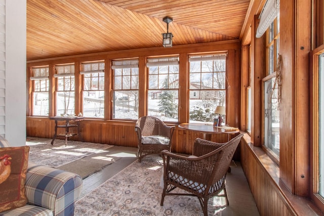 sunroom / solarium featuring wooden ceiling, wood walls, and a healthy amount of sunlight