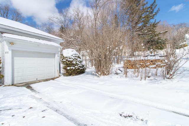 snowy yard featuring a garage