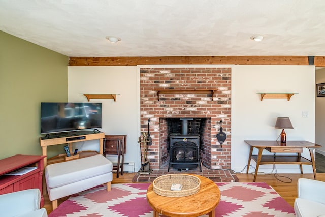 34 Ridge Rd, Jackson, NH 03846 - living area with a baseboard radiator, a wood stove, beam ceiling, and wood finished floors