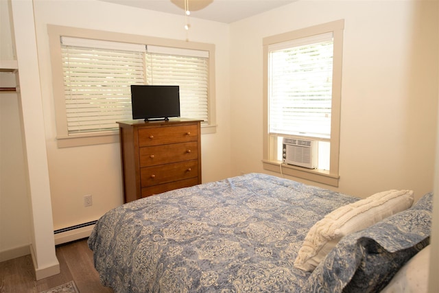 30 Pond St Unit 11, Ludlow, VT 05149 - bedroom with cooling unit, baseboards, baseboard heating, and wood finished floors