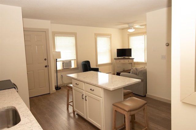 30 Pond St Unit 11, Ludlow, VT 05149 - kitchen with ceiling fan, white cabinetry, dark wood-type flooring, and a breakfast bar area