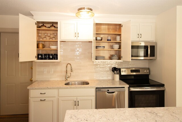 30 Pond St Unit 11, Ludlow, VT 05149 - kitchen featuring open shelves, stainless steel appliances, decorative backsplash, and a sink