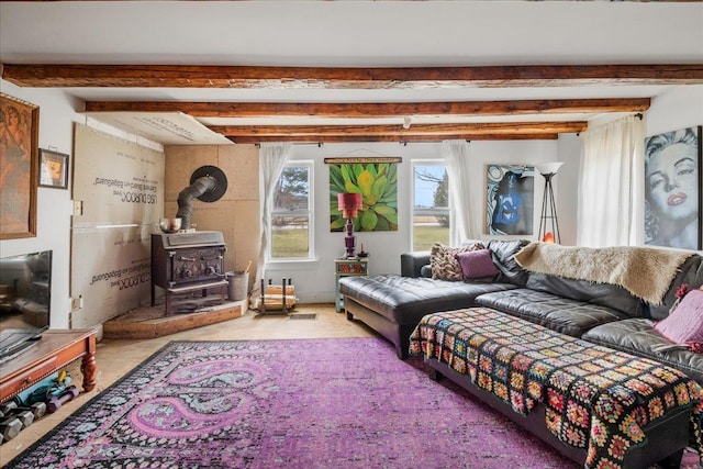 living area with beam ceiling and a wood stove