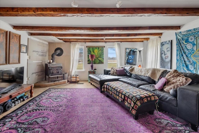 carpeted living room featuring beamed ceiling and a wood stove