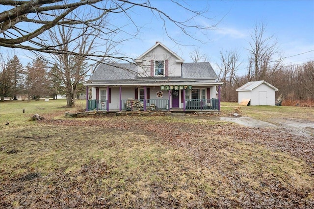 view of front of house with a storage shed, an outbuilding, a front yard, and covered porch