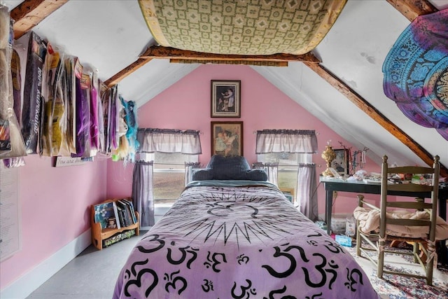 bedroom with concrete flooring, lofted ceiling, and baseboards