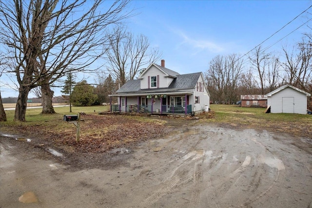 view of front of house featuring a chimney, a front lawn, a shed, an outbuilding, and a porch
