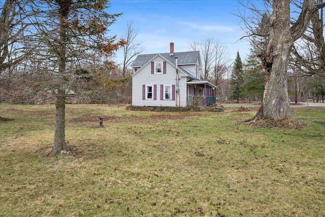 view of front of home with a chimney and a front yard