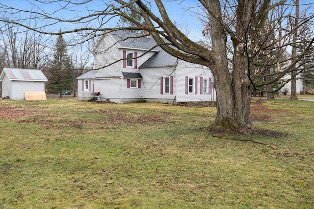 view of home's exterior featuring an outdoor structure, a yard, and a storage unit