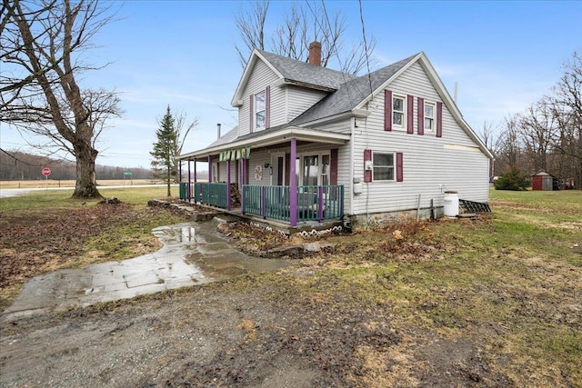 view of property exterior featuring a storage shed, a yard, a porch, and a chimney