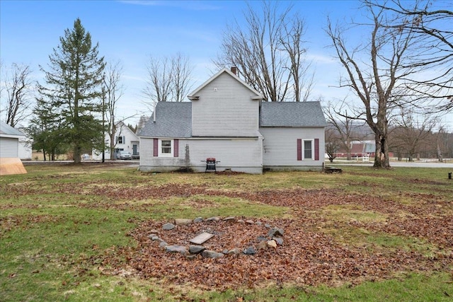 view of property exterior with a shingled roof and a yard