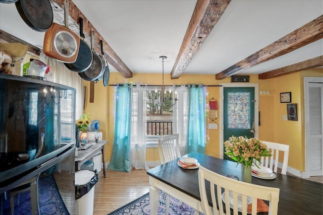 dining space with light wood-style floors, beam ceiling, and baseboards