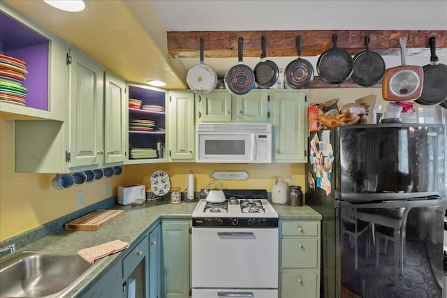 kitchen with light countertops, beam ceiling, green cabinets, and white appliances
