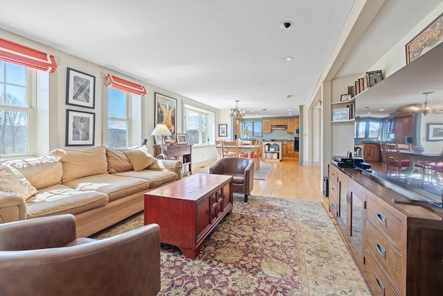 living room with a chandelier, light wood-style floors, and recessed lighting