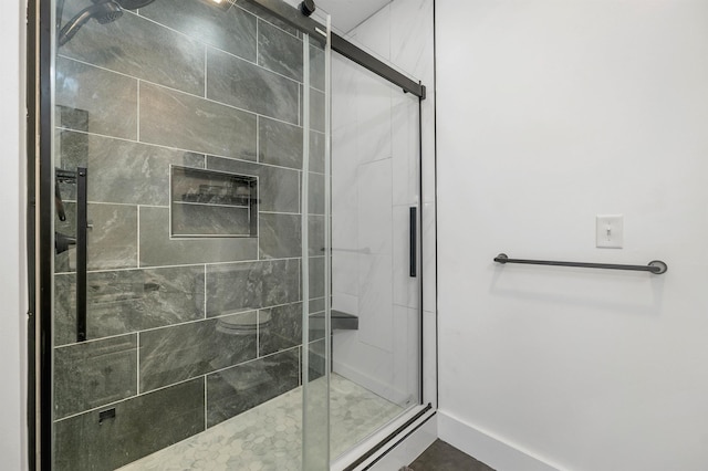 full bathroom featuring baseboards and a stall shower