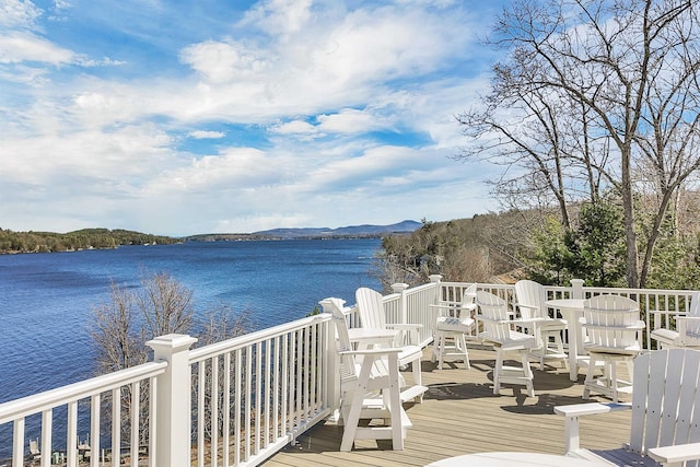 wooden terrace featuring a water and mountain view