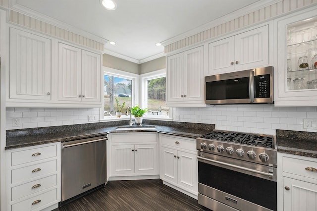 kitchen with crown molding, decorative backsplash, appliances with stainless steel finishes, and a sink