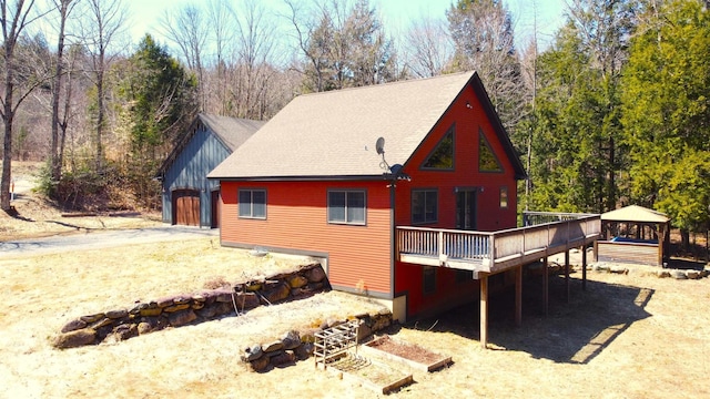 rear view of property featuring a wooden deck and a gazebo