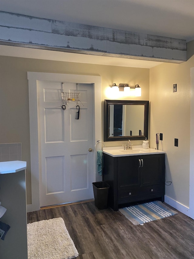 bathroom with baseboards, wood finished floors, and vanity