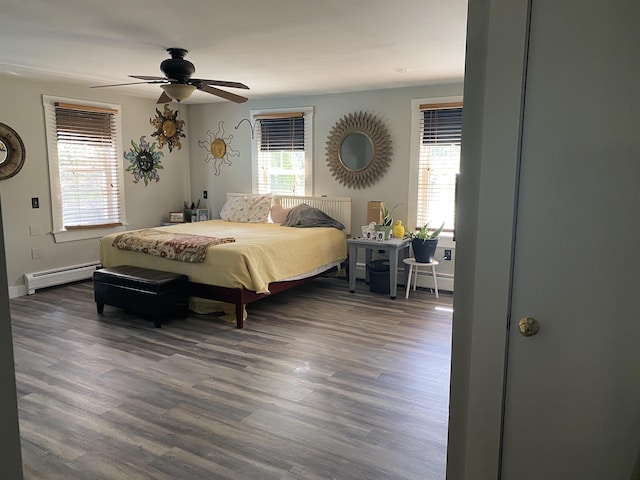 bedroom featuring dark wood-style flooring, baseboard heating, and multiple windows