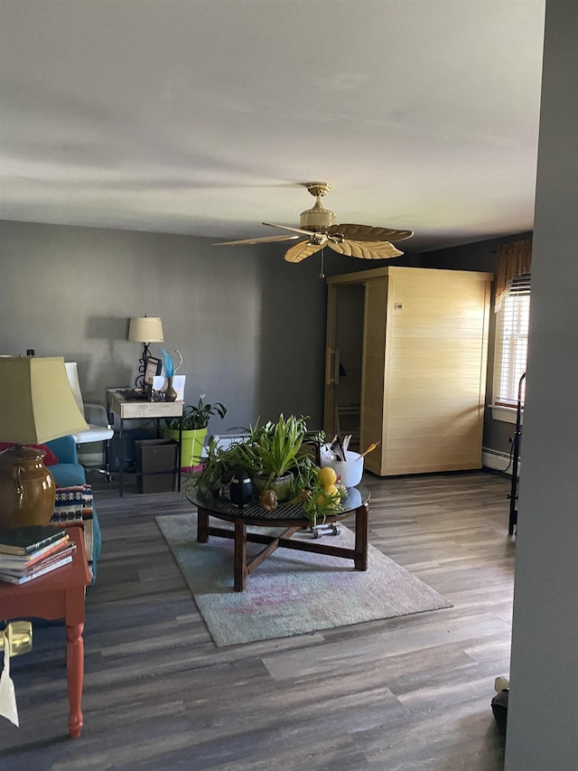 living room featuring ceiling fan, wood finished floors, and a baseboard radiator