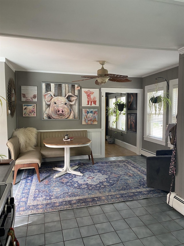 living area with a baseboard heating unit, a ceiling fan, tile patterned flooring, and crown molding