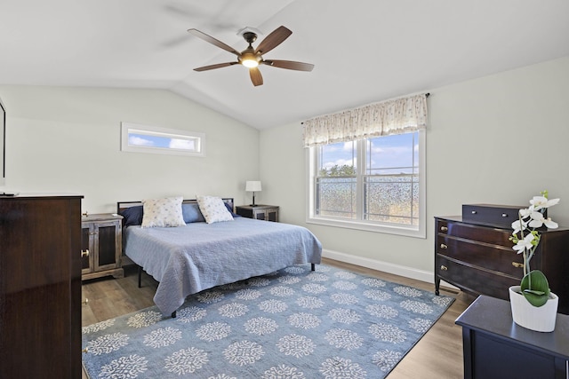 bedroom featuring lofted ceiling, wood finished floors, and multiple windows