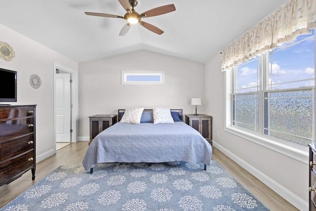 bedroom with baseboards, vaulted ceiling, wood finished floors, and a ceiling fan