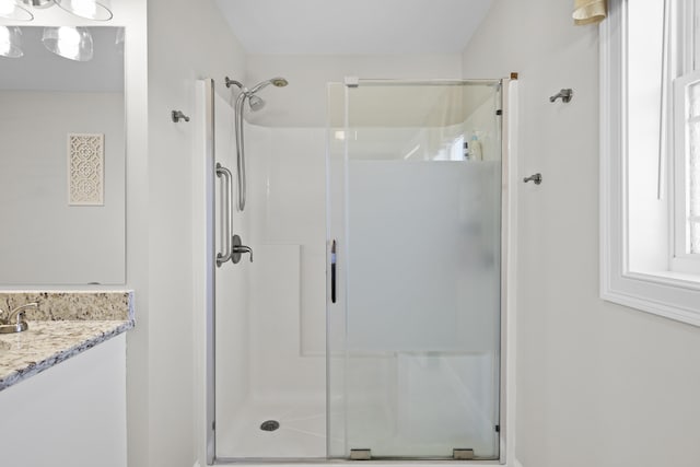 full bath with a shower stall and vanity