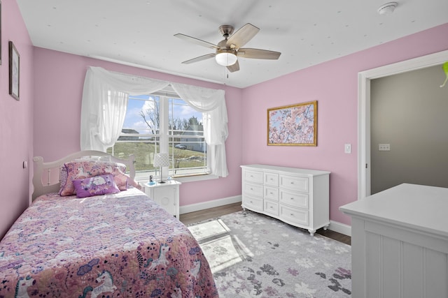 bedroom featuring light wood-type flooring, baseboards, and ceiling fan