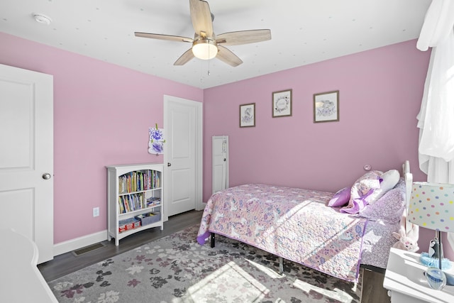 bedroom with ceiling fan, baseboards, wood finished floors, and visible vents