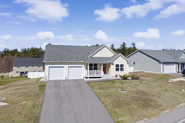 single story home with fence, an attached garage, driveway, covered porch, and a front yard