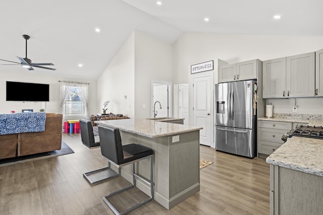 kitchen with high vaulted ceiling, open floor plan, stainless steel fridge, gray cabinets, and ceiling fan