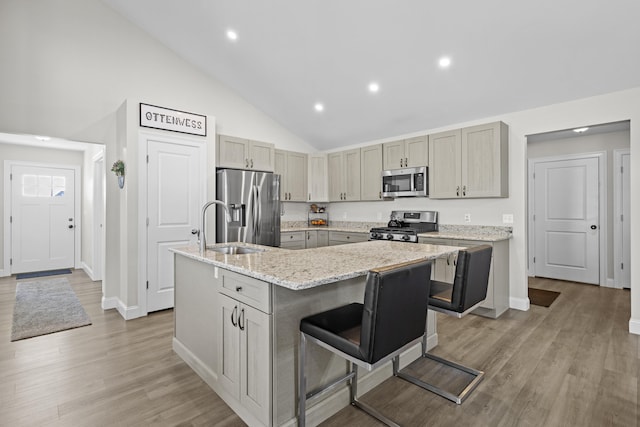 kitchen with recessed lighting, a sink, baseboards, a kitchen island with sink, and appliances with stainless steel finishes
