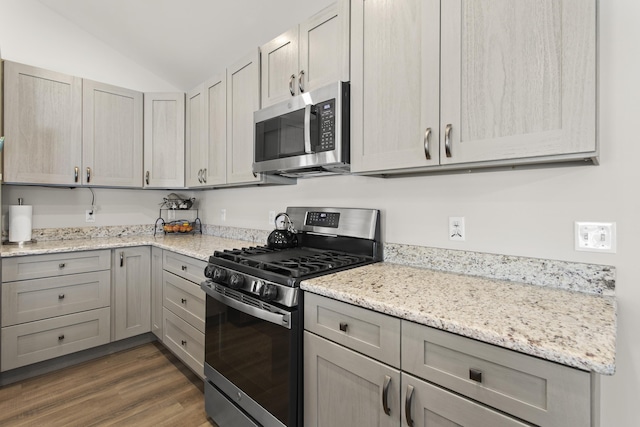 kitchen with light stone counters, dark wood finished floors, lofted ceiling, appliances with stainless steel finishes, and gray cabinetry