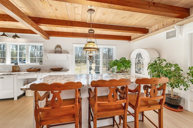 dining room with light wood-style floors, plenty of natural light, and visible vents