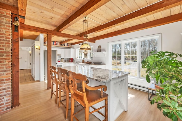 kitchen featuring light wood-type flooring, beam ceiling, white cabinetry, and wood ceiling
