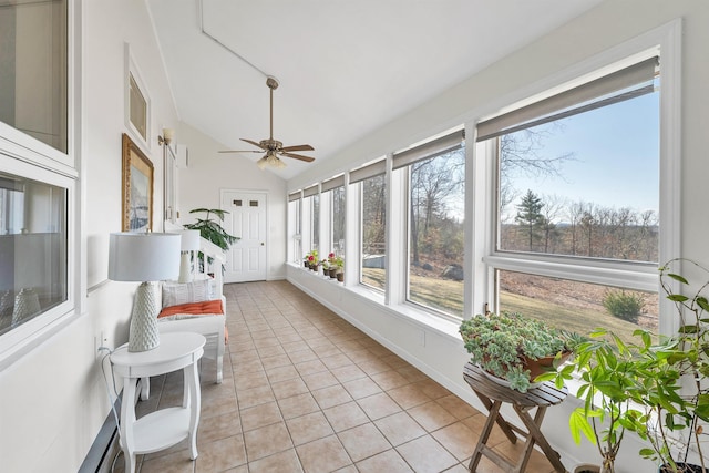 sunroom / solarium featuring lofted ceiling, tile patterned flooring, and baseboards