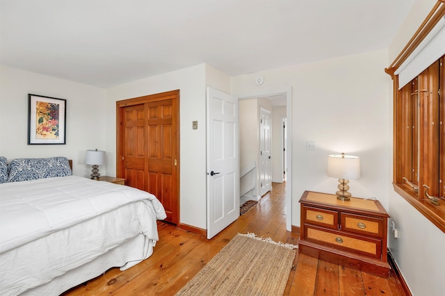 bedroom featuring a closet, light wood finished floors, and baseboards