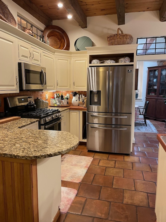 kitchen featuring beam ceiling, appliances with stainless steel finishes, wood ceiling, and decorative backsplash