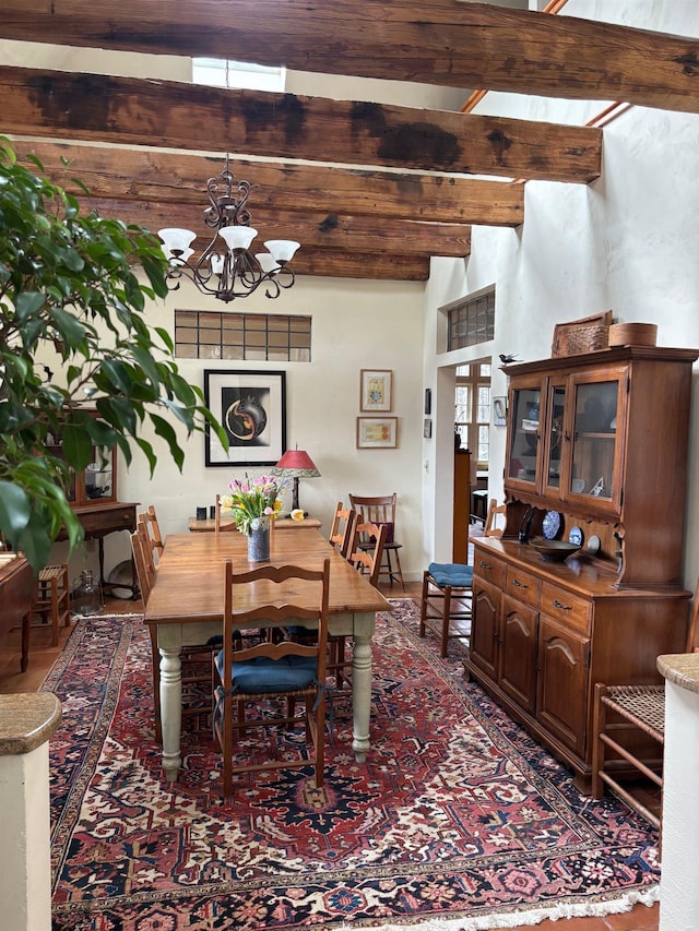 dining room featuring beamed ceiling and an inviting chandelier