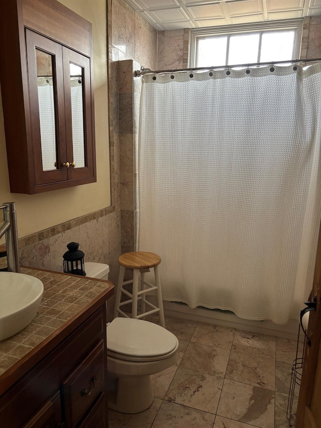 full bath with shower / bath combination with curtain, toilet, vanity, and tile walls