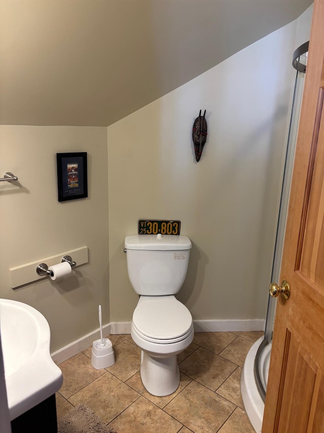 half bathroom featuring baseboards, tile patterned flooring, vanity, and toilet