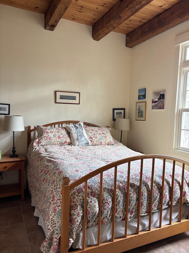 bedroom with wood ceiling, tile patterned flooring, and beam ceiling