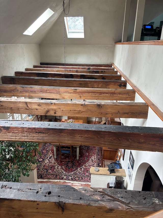 stairway featuring vaulted ceiling with skylight