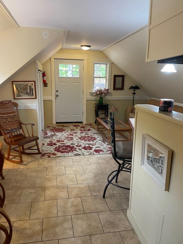 entrance foyer with light tile patterned flooring and vaulted ceiling