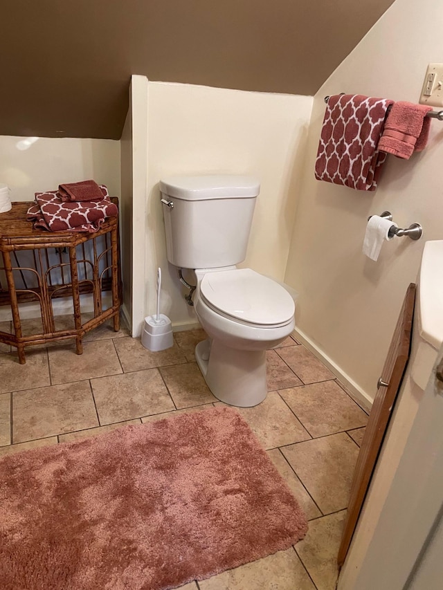 bathroom with toilet, baseboards, and tile patterned floors