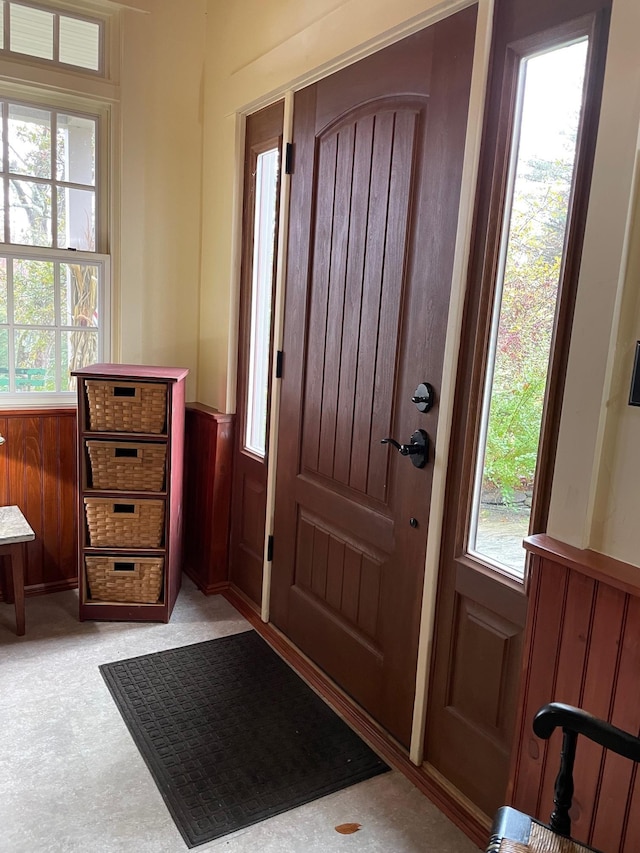 entrance foyer featuring wainscoting and light floors